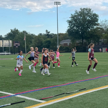 young children at field hockey practice on turf field
